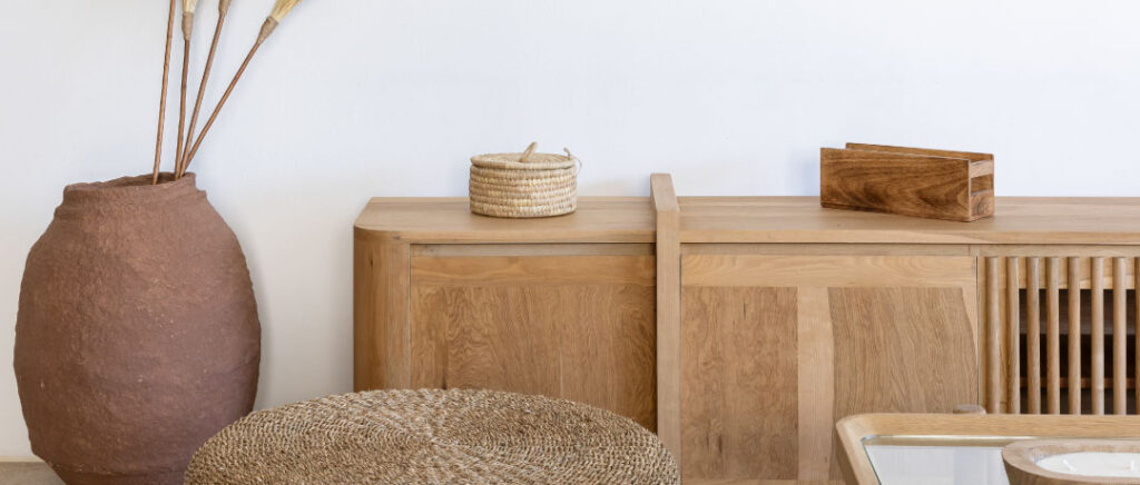 Muebles de madera clara y fibras naturales, representando el diseño consciente y la calidad en la elección de mobiliario para el hogar.