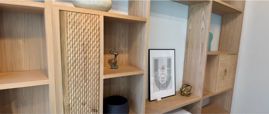 Detalle de repisa de madera con piezas de cerámica artesanal en una decoración interior